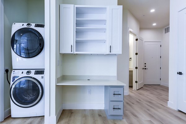 Laundry room with modern washers and dryers at The Tobin Estate Apartments