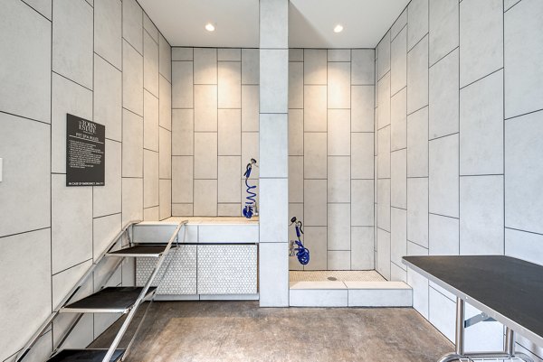 Dog wash station at The Tobin Estate Apartments featuring built-in sprayer and drying area Perfect for pet-friendly luxury living