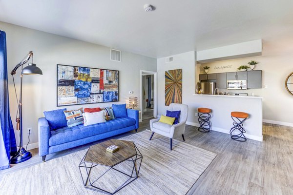 Modern living room with large windows and stylish decor in Sunstone Apartments, luxury living space by Greystar