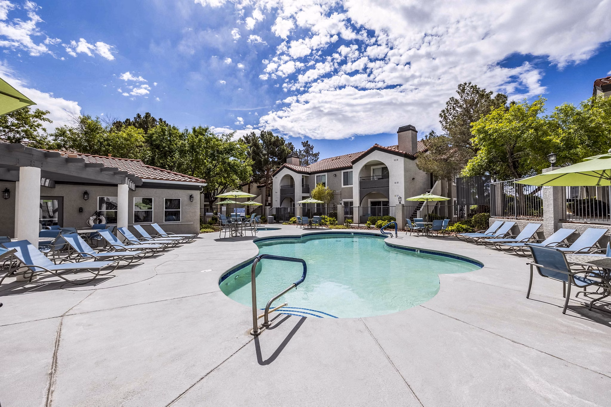 Sunny outdoor pool with lounge chairs at Sunstone Apartments offering luxury leisure