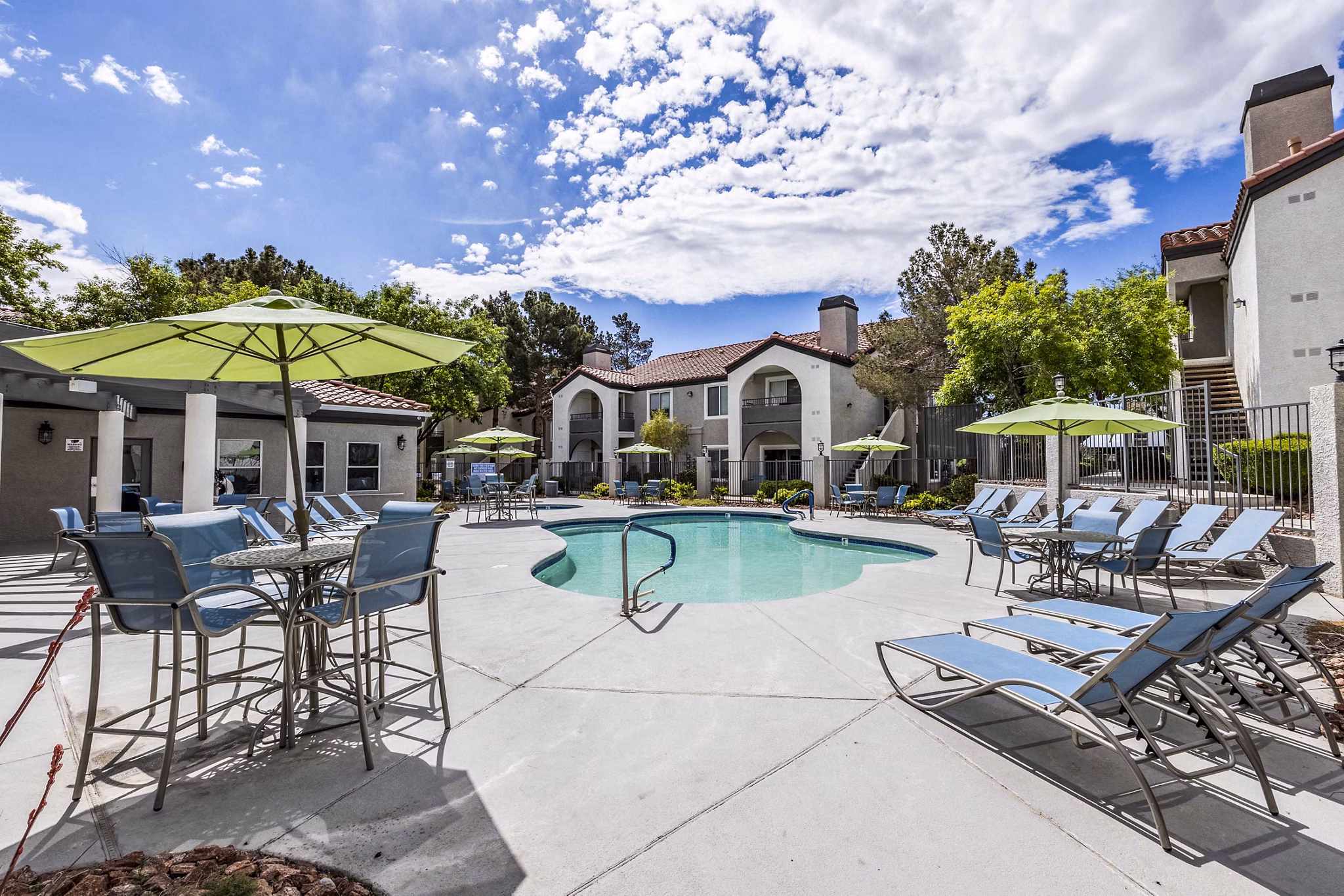 Resort-style pool with sun loungers at Sunstone Apartments, perfect for luxury living and relaxation