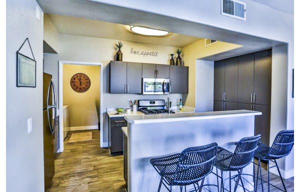 Modern kitchen with stainless steel appliances and island at Solitude at Centennial Apartments
