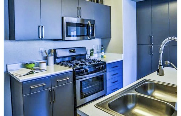 Stylish kitchen with sleek appliances and granite countertops in Solitude at Centennial Apartments