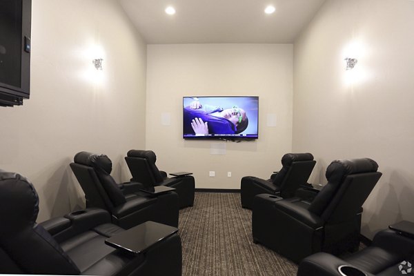 Theater room with plush seating and large screen at Central Park Commons Apartments