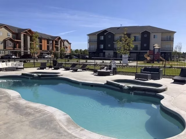 Resort-style pool with lounge chairs at Central Park Commons Apartments