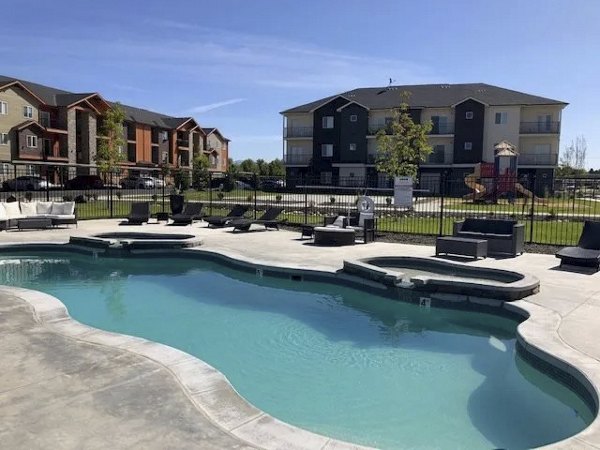 Resort-style pool with lounge chairs at Central Park Commons Apartments