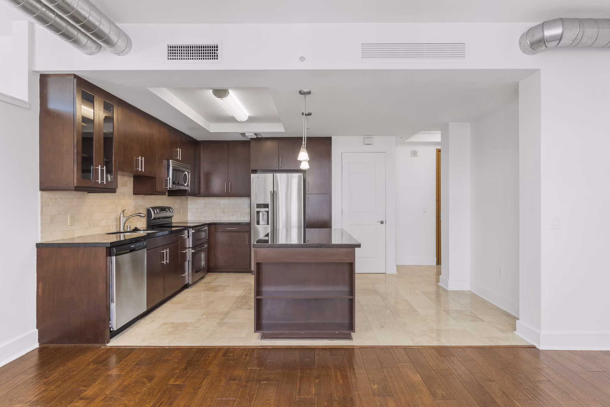 Modern kitchen with stainless steel appliances in 717 Olympic Apartments