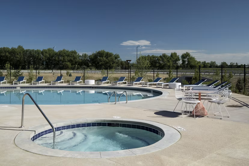 Resort-style pool with shaded lounge areas at Alexan Diagonal Crossing Apartments, offering luxury living in Boulder, Colorado