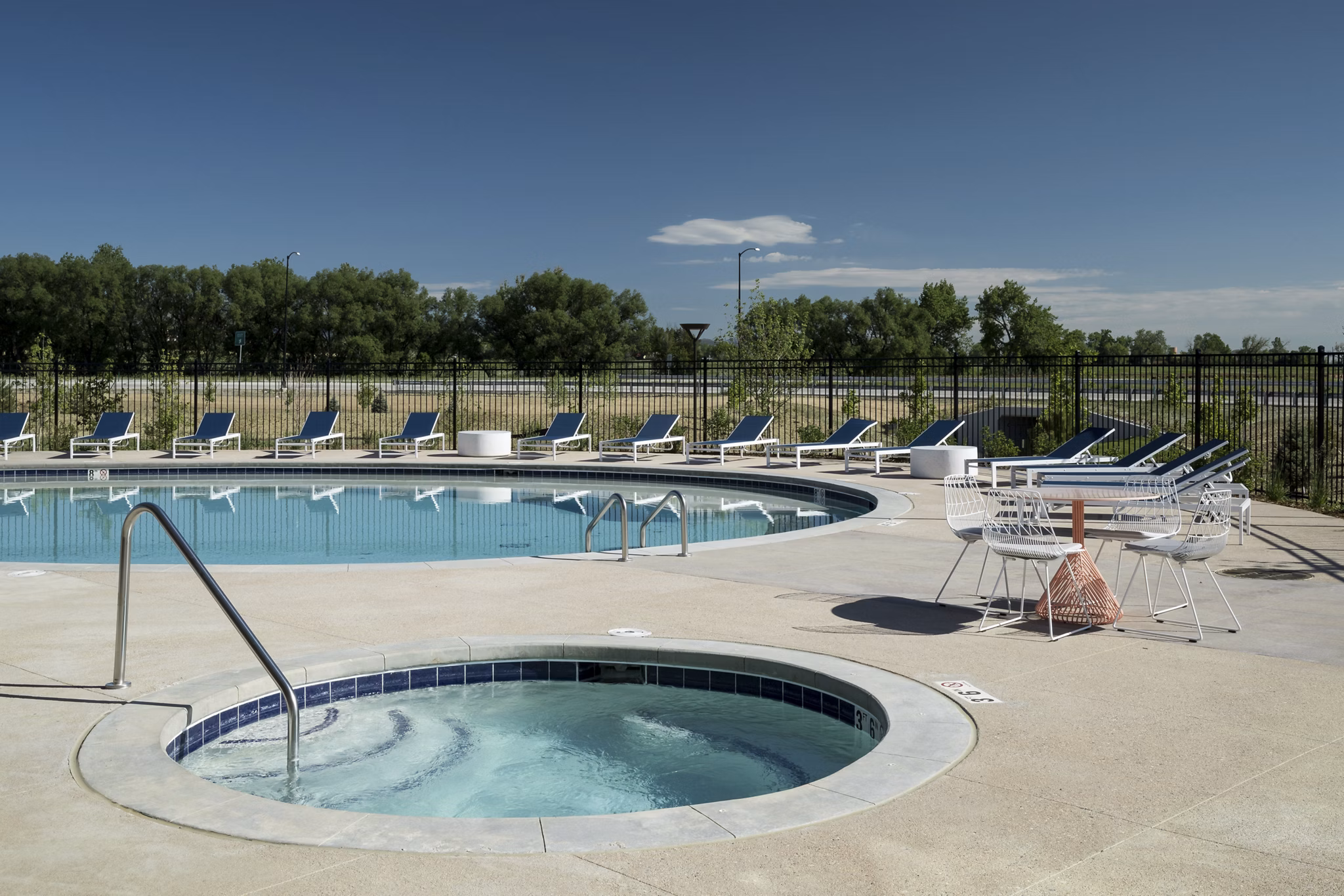 Resort-style pool with shaded lounge areas at Alexan Diagonal Crossing Apartments, offering luxury living in Boulder, Colorado