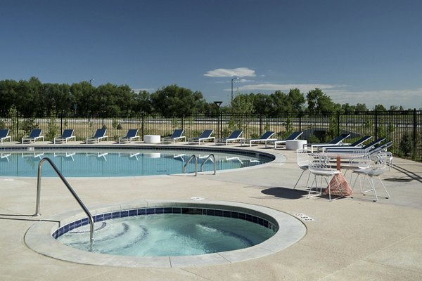 Resort-style pool with shaded lounge areas at Alexan Diagonal Crossing Apartments, offering luxury living in Boulder, Colorado