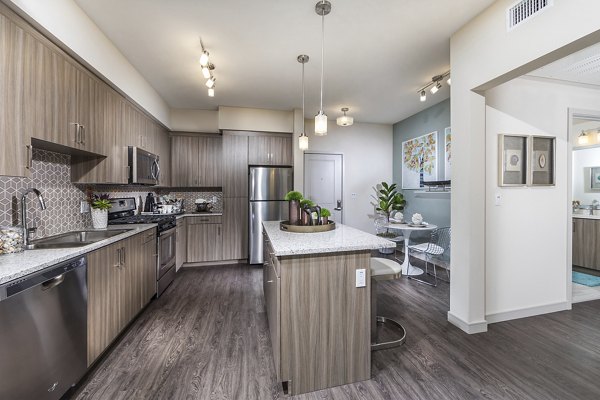 Modern kitchen with sleek countertops and stainless steel appliances at Areum Apartments
