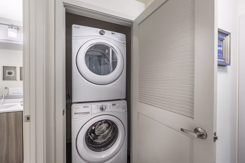 Modern laundry room with high-efficiency washers and dryers at Areum Apartments