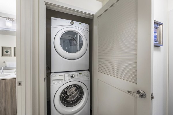 Modern laundry room with high-efficiency washers and dryers at Areum Apartments