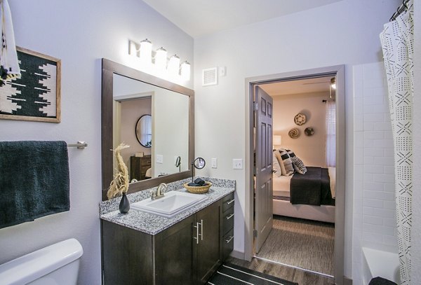 Bathroom featuring modern design and granite countertops at Volare Apartments