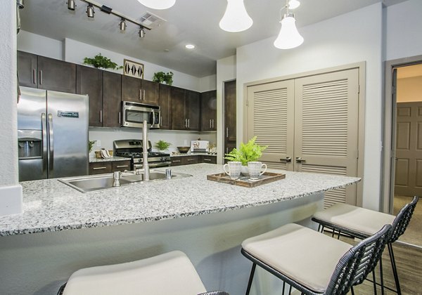 Modern kitchen featuring stainless steel appliances and quartz countertops at Volare Apartments
