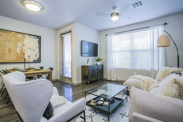Modern living room with elegant decor and ample natural light at Volare Apartments