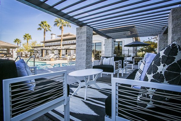 Outdoor patio with cozy seating and lush greenery at Volare Apartments, a luxury community managed by Greystar