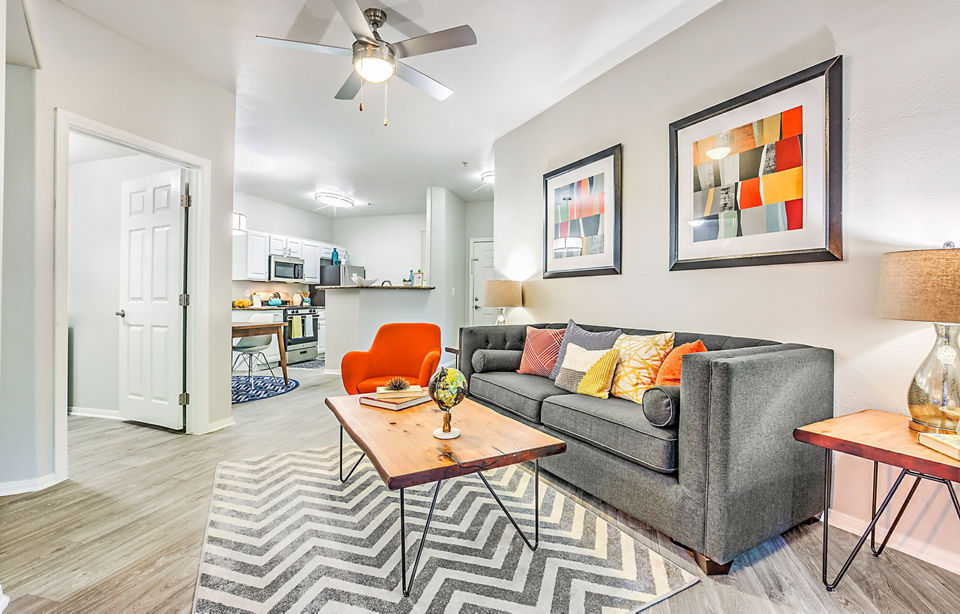 Living room with modern furnishings and large windows at Luminous Apartments offering luxury Greystar living experience