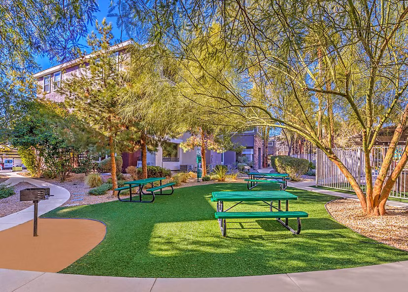 Lush picnic and recreational area with tables and seating at Luminous Apartments, ideal for outdoor gatherings