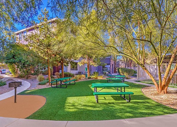 Lush picnic and recreational area with tables and seating at Luminous Apartments, ideal for outdoor gatherings