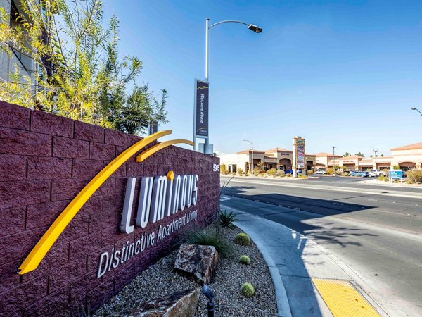 Luminous Distinctive Apartment Living entrance sign near commercial buildings in an urban setting