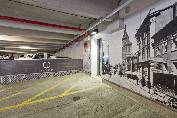 The Quincy Apartments: Spacious parking lot near luxury units in vibrant urban setting