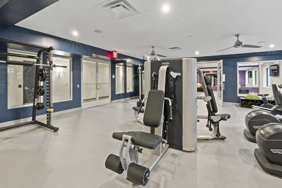 Fitness room with modern equipment at The Quincy Apartments