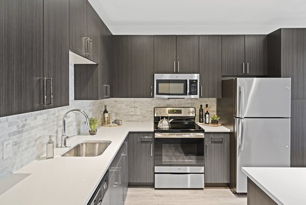 Bright kitchen with modern appliances and sleek countertops at The Quincy Apartments, a Greystar luxury living community