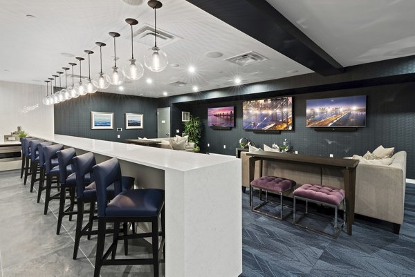 Media room with plush seating and large screens at The Quincy Apartments