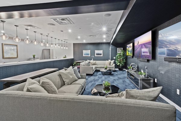 Media room with plush seating and large screen at The Quincy Apartments, ideal for entertainment and relaxation