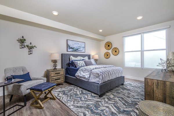 Bedroom with coastal decor and ocean views at Portside Ventura Harbor Apartments
