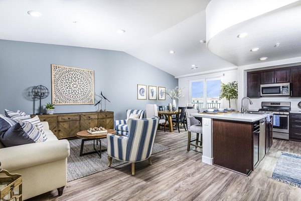 Spacious living room with contemporary decor at Portside Ventura Harbor Apartments, featuring cozy seating and ocean-inspired accents