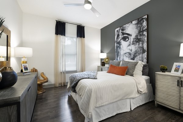 Cozy bedroom with modern decor at Atlas Waterside Apartments, featuring natural light and plush bedding