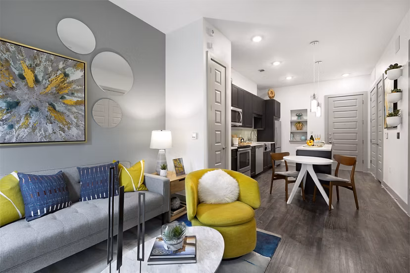 Spacious living room featuring modern decor and large windows at Atlas Waterside Apartments