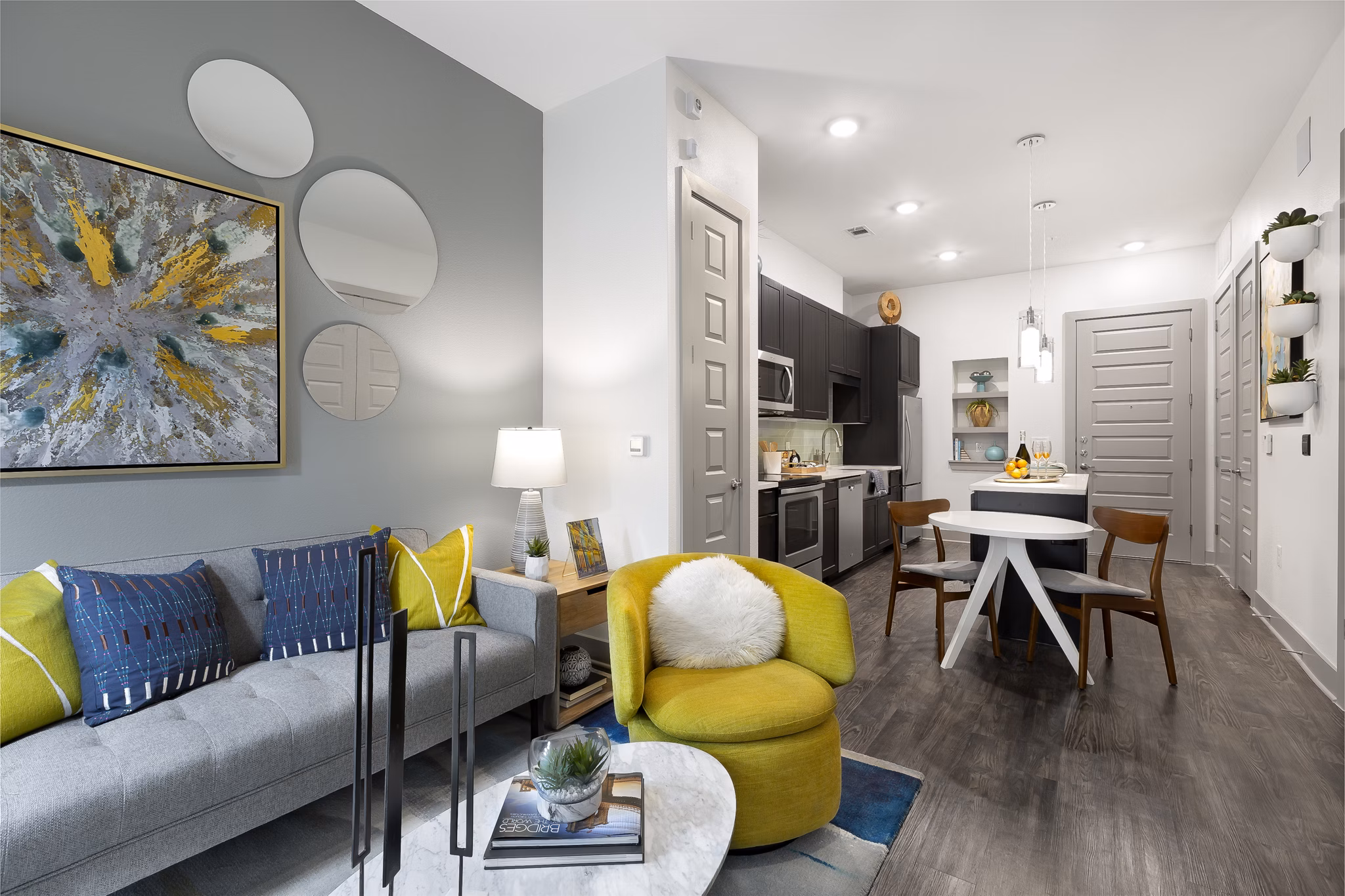 Spacious living room featuring modern decor and large windows at Atlas Waterside Apartments