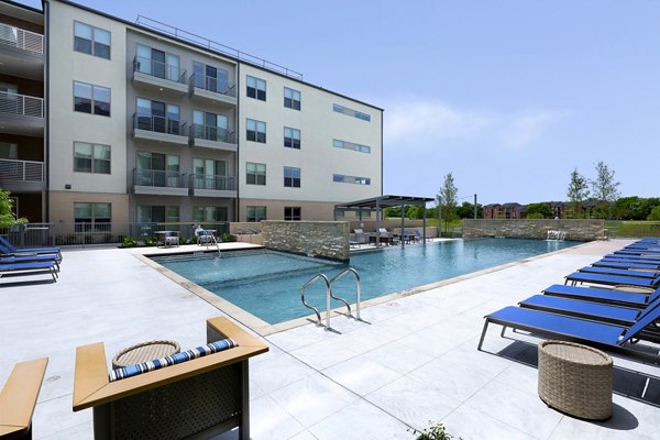 Large outdoor pool with lounge seating at Atlas Waterside Apartments, a luxury Greystar property in a prime location