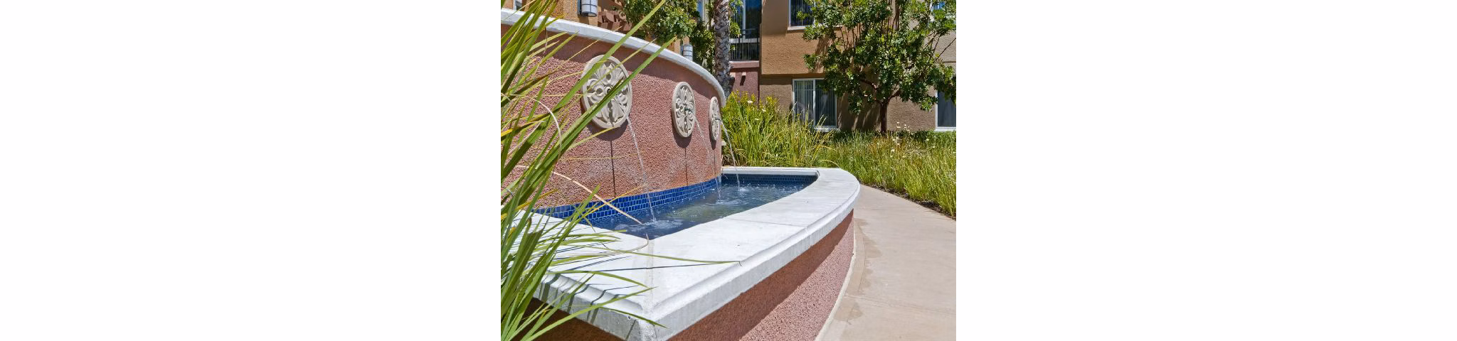 Fountain at Tamarind Square: Elegant water feature surrounded by lush landscaping at luxury Greystar apartments in prime urban location