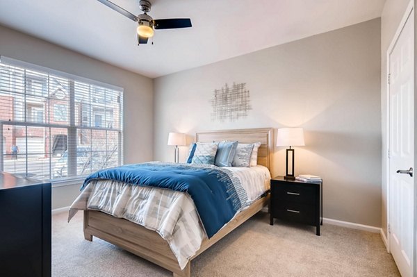 Cozy bedroom with modern furnishings in Lowry Park Apartments: Luxury urban living by Greystar