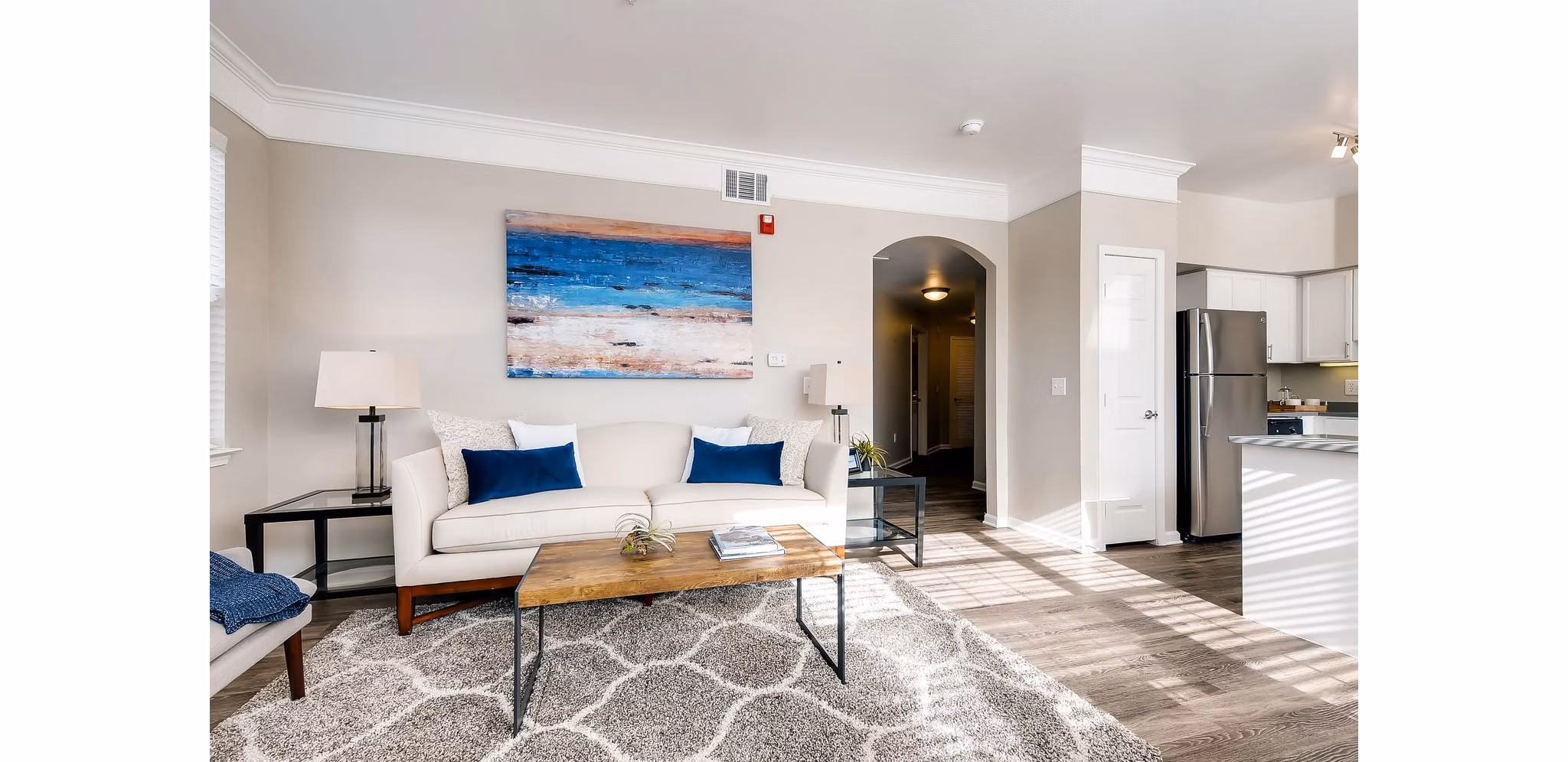 Cozy living room with modern decor at Lowry Park Apartments featuring a plush sofa and large windows