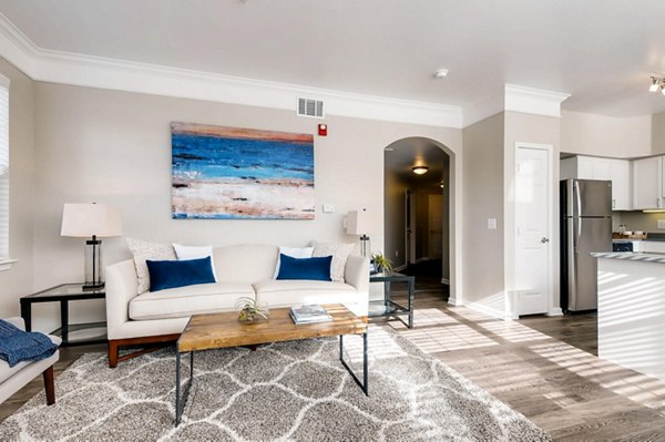 Cozy living room with modern decor at Lowry Park Apartments featuring a plush sofa and large windows
