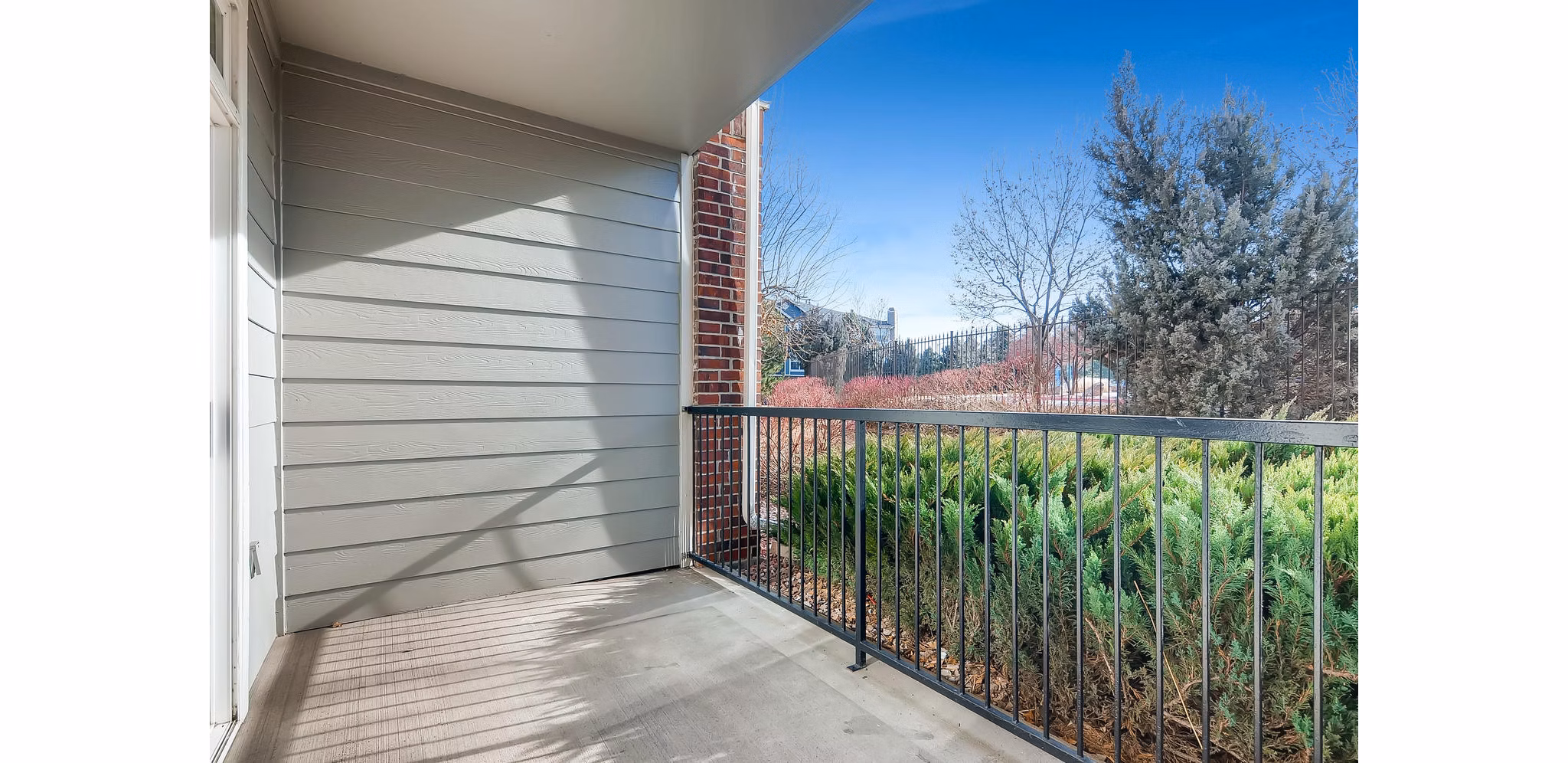 Modern patio with lounge chairs and greenery at Lowry Park Apartments, perfect for relaxation and socializing outdoors