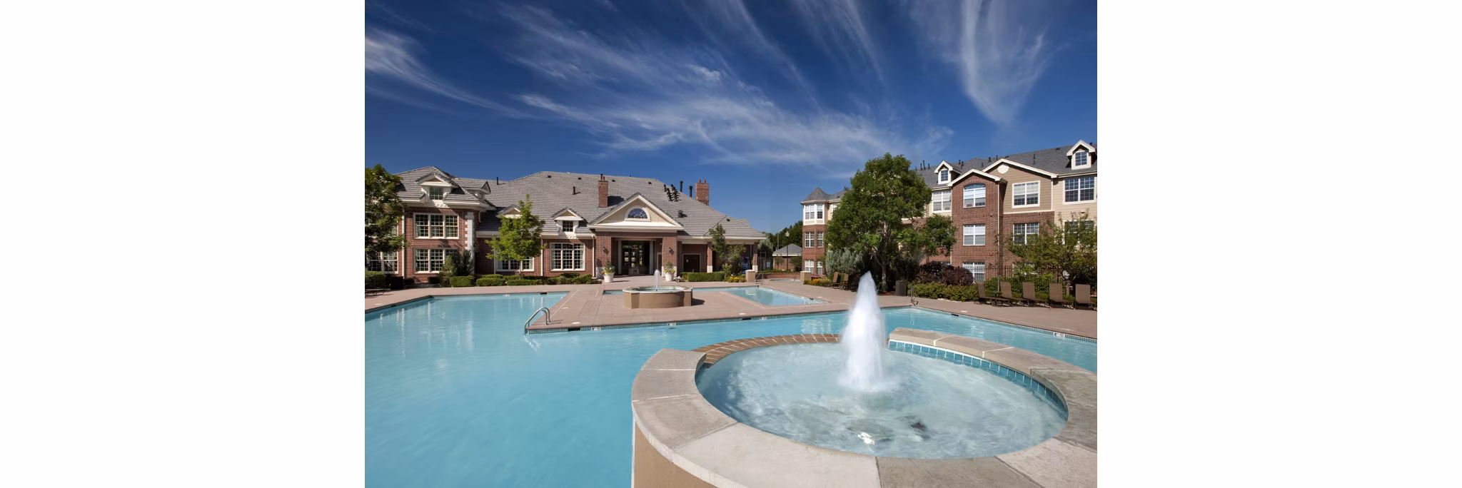 Swimming pool with sun loungers at Lowry Park Apartments, featuring serene surroundings for relaxing leisure time