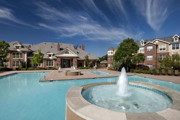 Swimming pool with sun loungers at Lowry Park Apartments, featuring serene surroundings for relaxing leisure time