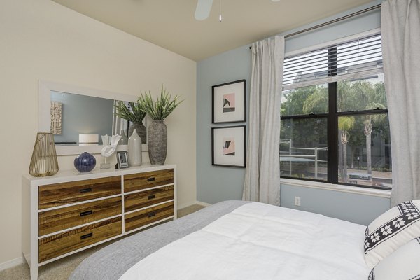 Modern bedroom with stylish decor and large windows in City Place Apartments