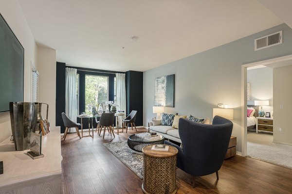 Luxurious living room with modern decor and large windows at City Place Apartments, offering comfort and style in urban living