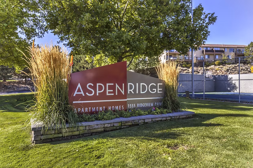 Aspen Ridge Apartments: Luxury apartment signage amidst landscaped surroundings