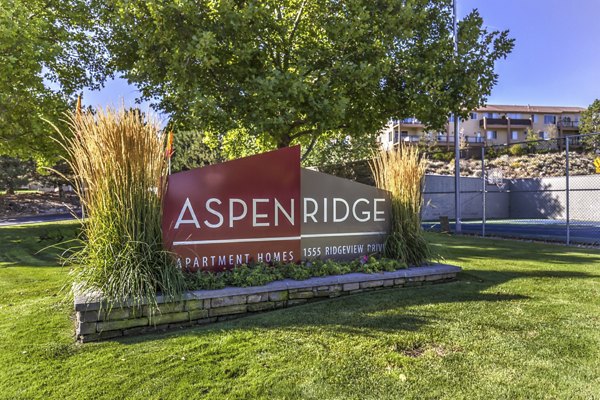 Aspen Ridge Apartments: Luxury apartment signage amidst landscaped surroundings
