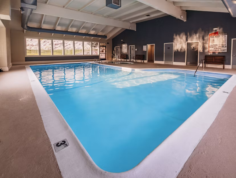 Indoor pool with lounge chairs at Aspen Ridge Apartments, a Greystar luxury residence offering premium amenities
