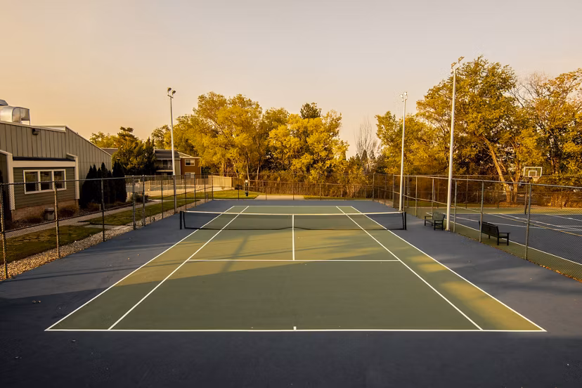 Aspen Ridge Apartments: Outdoor sport court featuring basketball hoops and tennis lines for active living