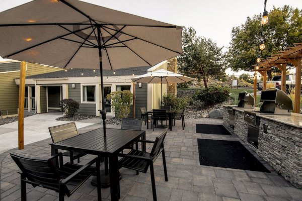 Outdoor grilling area at Aspen Ridge Apartments with modern stainless steel grills and seating, perfect for gatherings and relaxation